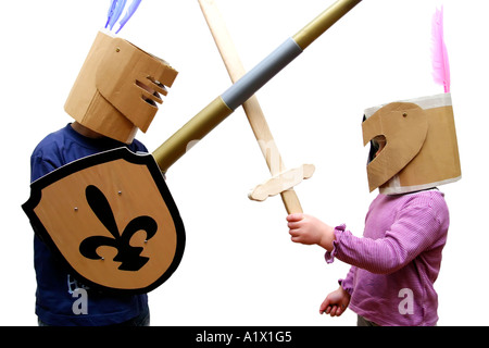 Garçon de 5 ans et fille de 2 ans se faisant passer pour des chevaliers en armure avec des casques en carton Banque D'Images