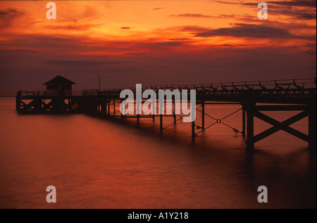 Coucher du soleil à Totland Bay avec Pier ossature Ile de Wight Angleterre UK Banque D'Images