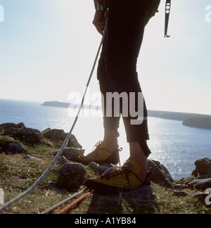 Un grimpeur de rochers se tenant au bord de la falaise au-dessus de Mowingword Bay Stackpole dans le Pembrokeshire South Wales UK KATHY DEWITT Banque D'Images