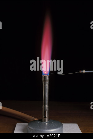 Test de flamme de strontium, montrant une flamme rouge cramoisi brillant, réalisé avec un brûleur de bunsen, un fil de platine et de nichrome. Isolé sur le noir. Banque D'Images