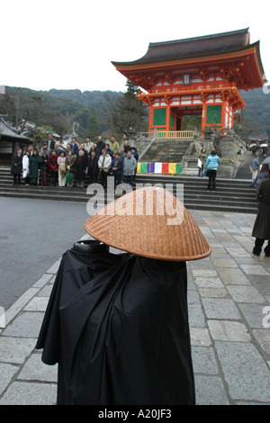 Un moine recueille des dons à l'extérieur de la porte de la dera Kiyomizu temple bouddhiste, Kyoto, Japon Banque D'Images