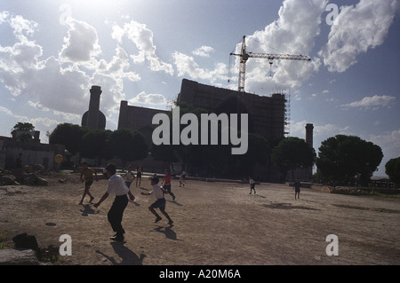 Les enfants jouent au football en face de la Mosquée de Bibi Khanym, Samarkand, Ouzbékistan. Cei Banque D'Images