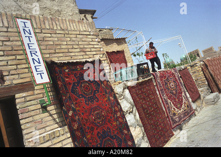 Un commerçant de tapis boutique avec un accès internet dans l'ancienne route commerciale de la route de la soie ville de Boukhara, Ouzbékistan, CIS Banque D'Images