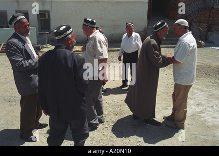 L'ouzbek hommes saluent à l'Abdullakhan Rabat mosquée après la prière dans la ville de Osh, Kirghizistan, Ferghana Banque D'Images