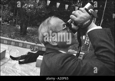 Un homme dormir après son hanami party, pour ses cerisiers en fleurs l'affichage, l'Ueno, Tokyo, Japon Banque D'Images