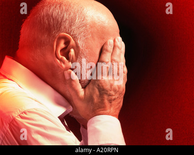 Middle aged Businessman with head in hands, profile Banque D'Images