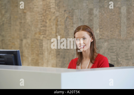 Woman sitting at desk, portrait Banque D'Images