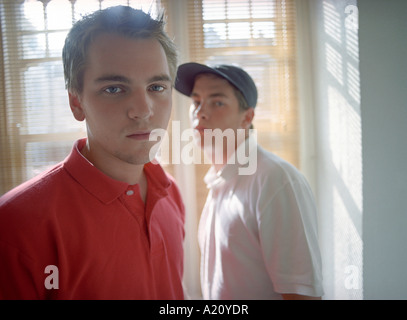 Adolescents (16-18) standing in front of window, portrait Banque D'Images