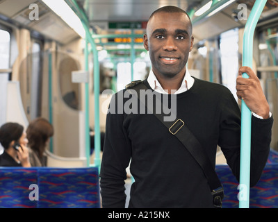 Sourire permanent sur le train de banlieue, holding bar Banque D'Images