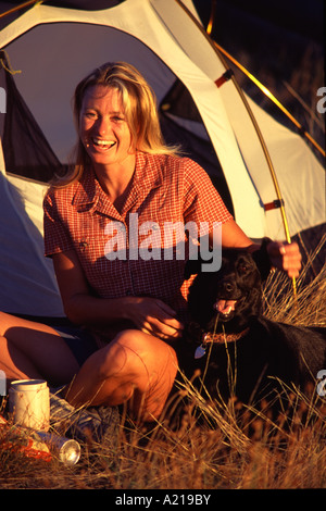 Une femme et son chien camping à Sommet Donner Californie au coucher du soleil Banque D'Images