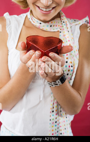 Woman Holding Heart-Shaped Box Banque D'Images