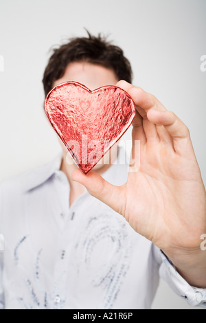 Man Holding Heart-Shaped Box Banque D'Images