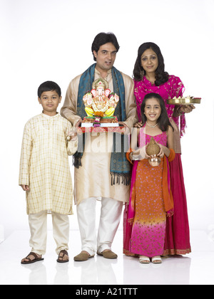 Le holding de la famille indienne de l'Asie du Sud statue de seigneur Ganesha Kalash Arati et thali portant un costume traditionnel kurta pajama Banque D'Images