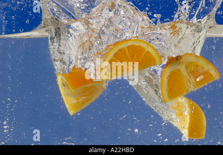 Fruits orange est tombé dans l'eau faire splash Banque D'Images