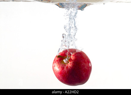 Pomme fruit est tombé dans l'eau faire splash Banque D'Images