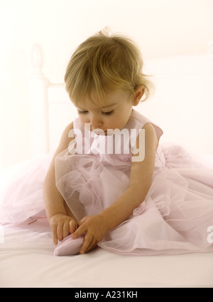 Porter un enfant en robe rose mise sur des chaussures de ballet Banque D'Images