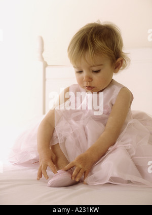 Porter un enfant en robe rose mise sur des chaussures de ballet Banque D'Images