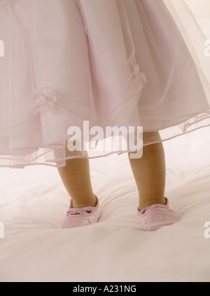 Porter un enfant en robe rose avec des chaussons de danse - image recadrée Banque D'Images