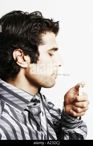 Portrait d'un jeune homme d'un éclairage avec un briquet bidi Banque D'Images