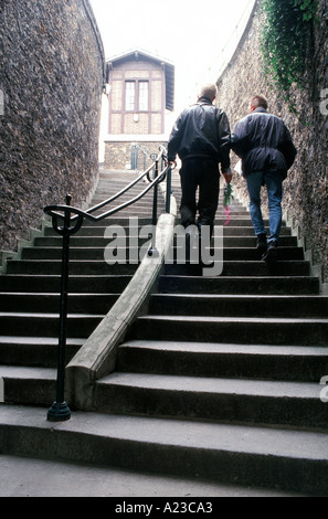 Paris France, gay couple masculin, hommes à pied, vers le haut, escalade, escalier au cimetière du Père Lachaise, escaliers extérieurs Banque D'Images