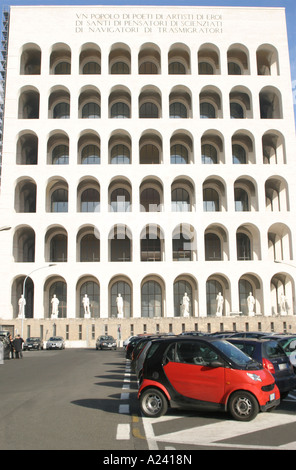 Smart rouge voiture garée à l'extérieur du Palazzo della Civilita ou carrés Coliseum en EUR ,L'EUR quartier à Rome Italie Banque D'Images