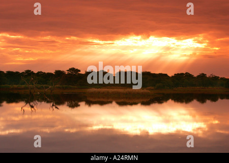 La Namibie mont Etjo Afrika rayons de soleil percer les nuages et se reflétant dans le lac Mont Etjo Afrique Namibie Banque D'Images