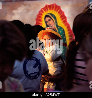 Les jeunes enfants étant photographiés devant la Vierge Guadalupe au fiesta du jour de la Vierge Mazatlan Mexique Banque D'Images