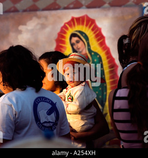 Les jeunes enfants étant photographiés devant la Vierge Guadalupe au fiesta du jour de la Vierge Mazatlan Mexique Banque D'Images