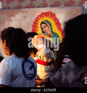 Les jeunes enfants étant photographiés devant la Vierge Guadalupe au fiesta du jour de la Vierge Mazatlan Mexique Banque D'Images