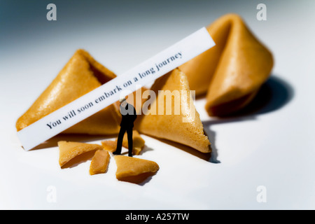 Businessman miniature en face de fortune cookies avec lecture de message Vous allez bientôt entamer un long voyage Banque D'Images