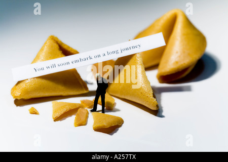 Businessman miniature en face de fortune cookies avec lecture de message Vous allez bientôt entamer un long voyage Banque D'Images