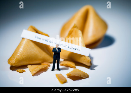 Businessman miniature en face de fortune cookies avec lecture de message vous auront beaucoup de succès Banque D'Images