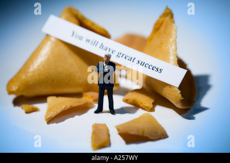 Businessman miniature en face de fortune cookies avec lecture de message vous auront beaucoup de succès Banque D'Images