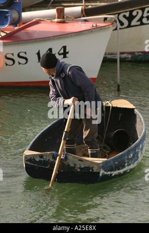 Les pêcheurs locaux à l'aide d'une rame de bateau de pêche en barque vers St Ives Cornwall UK Banque D'Images