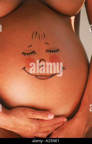 Femme enceinte avec sourire dessiné sur son ventre Banque D'Images