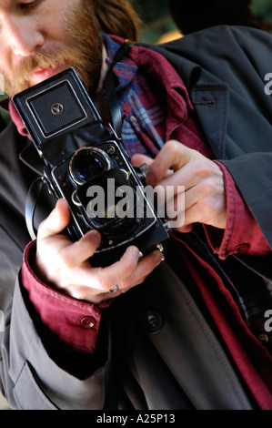 Un vieux de 30 ans, barbu man holding et de photographier avec un vieux Yashica appareil reflex bi-objectif Banque D'Images