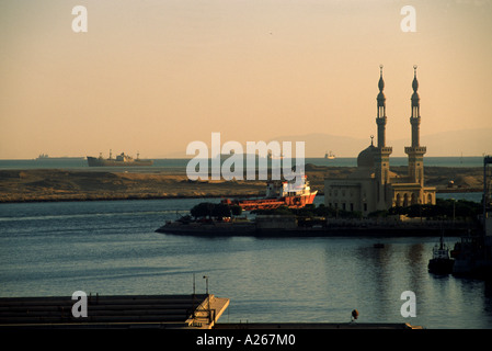 Une mosquée, en Egypte, à l'ouest de la péninsule du Sinaï se trouve à côté du canal de Suez comme un cargo passe à proximité. Banque D'Images