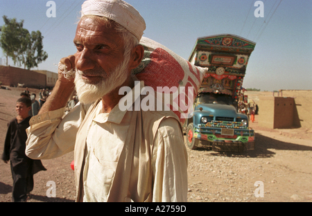 Un réfugié afghan prend sa nourriture accueil pour le mois à venir dans le camp de réfugiés de Shamshatoo. Banque D'Images