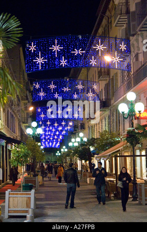 Les poussettes appréciant les illuminations de Noël l'éclairage sur la rue de Paradis à Nice sur la côte d'Azur Banque D'Images