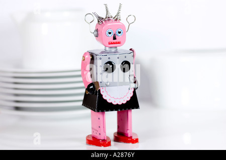 Femme tin toy robot debout devant des plats internationaux Banque D'Images