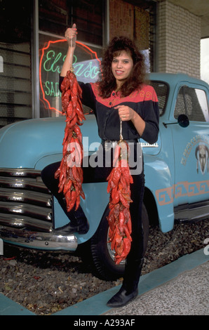 Saleswoman détient des grappes de piments rouges en face d'une voiture d'époque à l'El Paso Saddleblanket Store à El Paso au Texas Banque D'Images