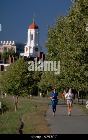 Deux femmes jogging le long du chemin sur les rives de la rivière Charles avec l'Université de Harvard, Dunster House à l'arrière Cambridge, Massachusetts Banque D'Images