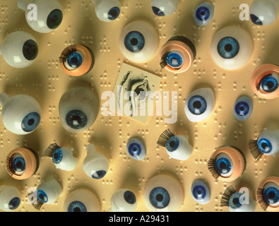 La vie encore montage de différents globes oculaires en plastique sur une page de braille Banque D'Images