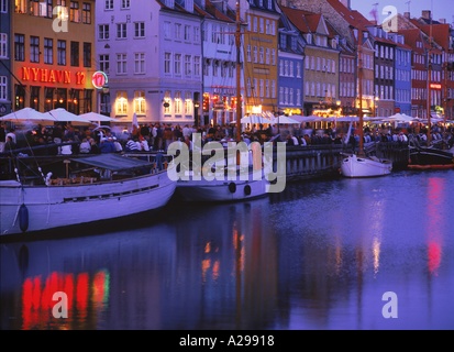 Bateaux amarrés et cafés en plein air sur le front de la canal de Nyhavn le vieux port de Copenhague Danemark La photo Store Banque D'Images