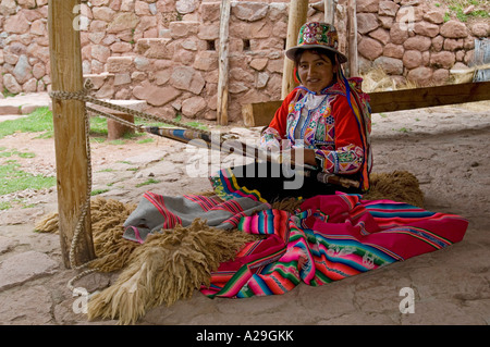 Une femme péruvienne smiling habillés en vêtements traditionnels démonstration de tissage de tissus. Banque D'Images