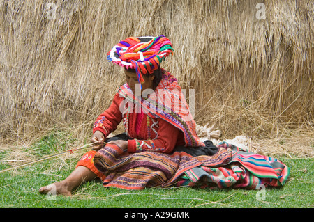 Une femme péruvienne habillés en vêtements traditionnels démonstration de tissage de tissus. Banque D'Images