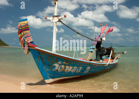 La côte nord de Ko Samui Thaïlande Laem Bangrak Mai Kaen chiffon coloré bateau de pêche liées car bonne chance garland sur la rive à proue Banque D'Images