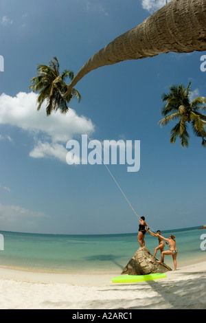 Thaïlande Ko Phangan Pha Ngan nord plage de Haad Khom touristes jouant sur la pendaison swing de coconut palm tree Banque D'Images