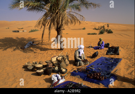 Touareg assis dans le sable et la vente de souvenirs, la Libye Banque D'Images