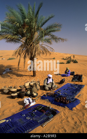 Touareg assis dans le sable et la vente de souvenirs, la Libye Banque D'Images